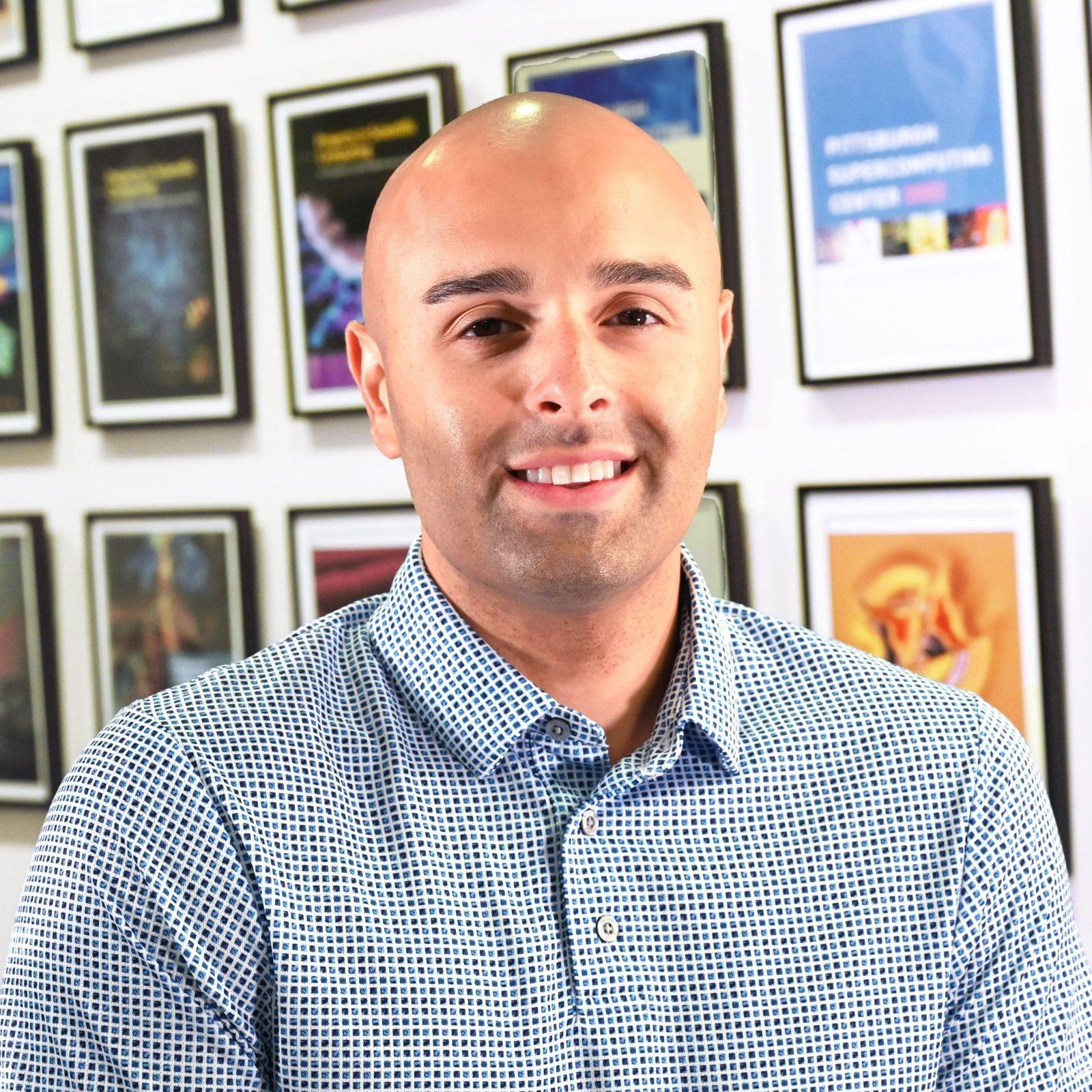 A man with medium-light skin tone and brown hair smiles at the camera.