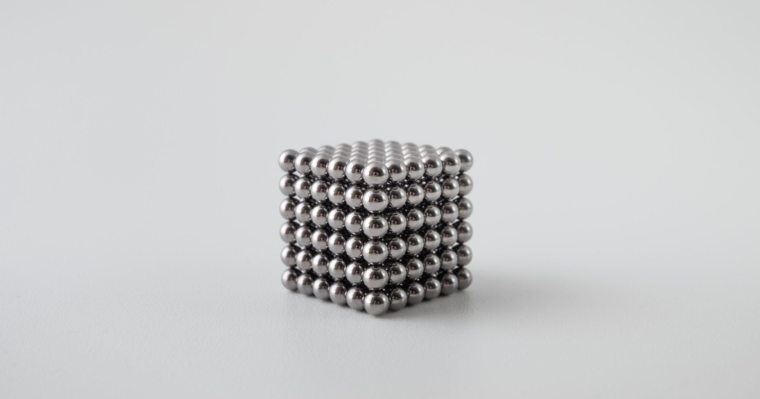 Spherical ball-bearing magnets formed in the shape of a cube.