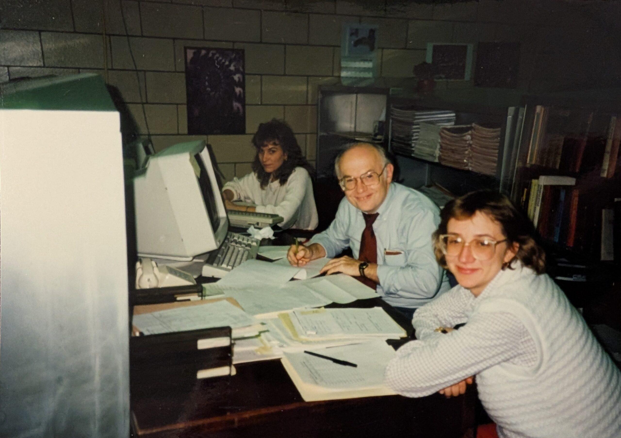 Deb at a computer with colleagues.